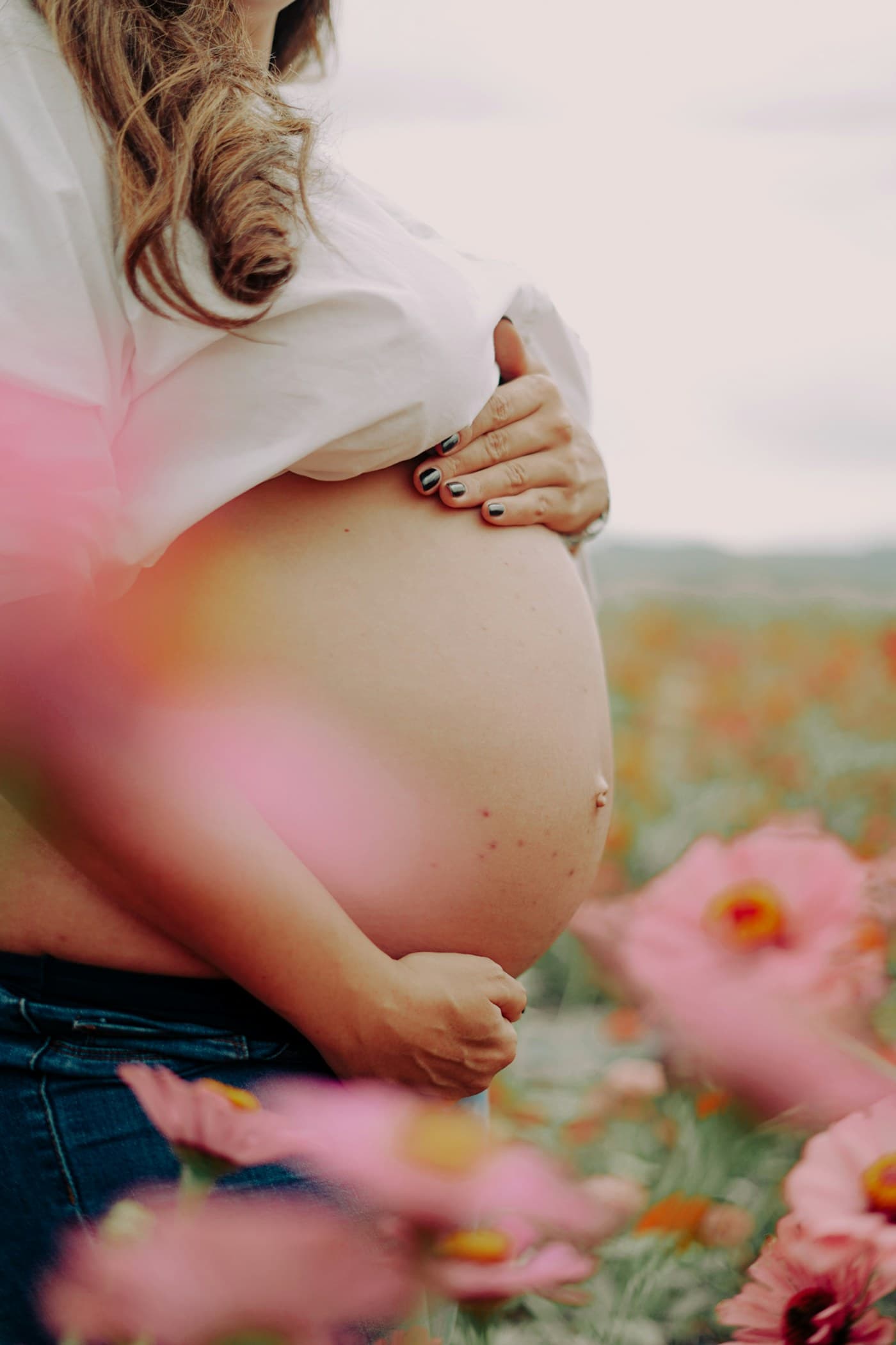 A quiet pregnancy moment among flowers